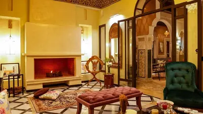 a living room with a fireplace and a couch at Dar Lys Luxury Riad & Spa in Fès