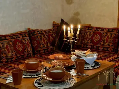 a table with plates of food and candles on it at Chateau Imilchil in Imilchil
