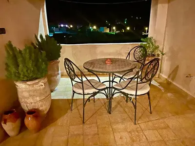 a table and chairs on a balcony at night at Chateau Imilchil in Imilchil