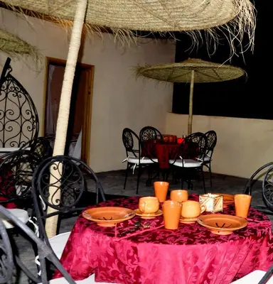 a table with a red table cloth and candles on it at Chateau Imilchil in Imilchil