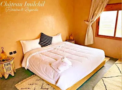 a large white bed in a bedroom with a window at Chateau Imilchil in Imilchil