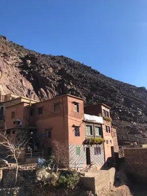 a building in front of a mountain at Gite La belle vue Timichi in Timichi