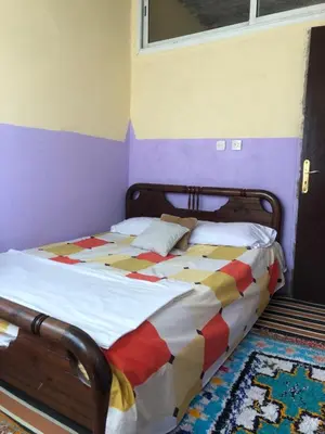 a bedroom with a bed with a colorful comforter at Gite La belle vue Timichi in Timichi