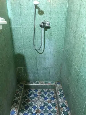 a bathroom with a shower with a tiled floor at Gite La belle vue Timichi in Timichi