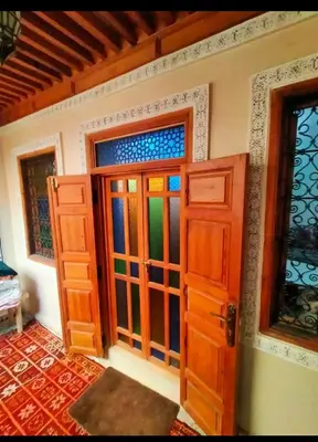 a room with a door with stained glass at famille fahym in Fès
