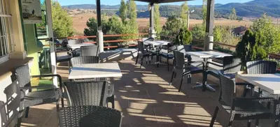 a patio with tables and chairs on a balcony at Auberge Tourtite in Ifrane
