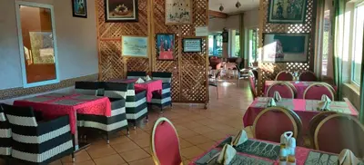 a restaurant with pink and black tables and chairs at Auberge Tourtite in Ifrane