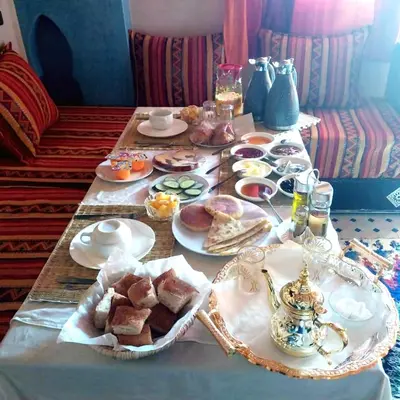 a table with plates of food on top of it at Riad Hassi Labied Merzouga in Merzouga