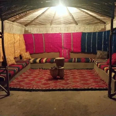 a room with couches and a rug in a tent at Riad Hassi Labied Merzouga in Merzouga