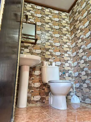 a bathroom with two toilets and a stone wall at Hotel Zagour - Luxury hotel in Zagora in Zagora