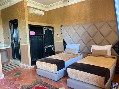 a bedroom with two beds and a door in it at Hotel Zagour - Luxury hotel in Zagora in Zagora