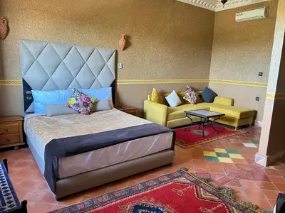 a bedroom with a king sized bed and a couch at Hotel Zagour - Luxury hotel in Zagora in Zagora