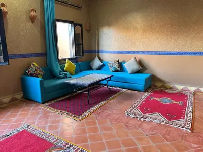 a living room with a blue couch and a table at Hotel Zagour - Luxury hotel in Zagora in Zagora