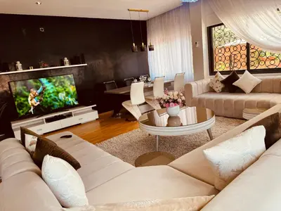 a living room with a white couch and a tv at la vue panoramique in Marrakech