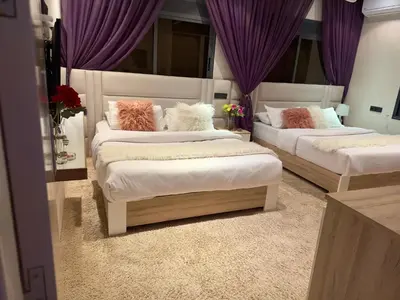 two beds in a room with purple curtains at la vue panoramique in Marrakech