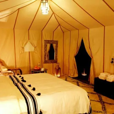 a bedroom with a large bed in a tent at Khadija Desert Camp in Merzouga