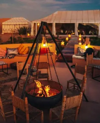 a fire pit with chairs and a couch in a backyard at Khadija Desert Camp in Merzouga