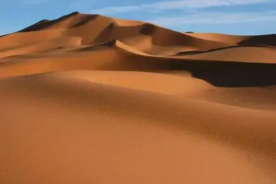 a sand dune in the desert with the sky in the background at Desert Erg Chigaga Lodge in El Gouera