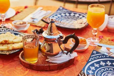 a table with a tea kettle and some drinks on it at Desert Erg Chigaga Lodge in El Gouera