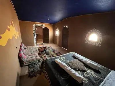 a room with a bed and a couch in it at Sahara Authentic Berber Camp in Mhamid