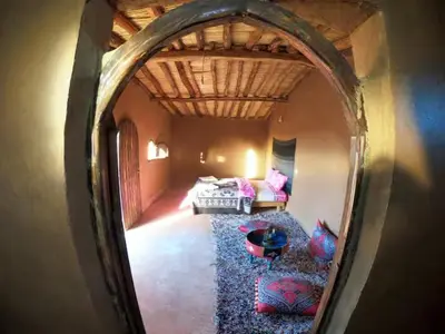 a reflection of a room with a bed and a mirror at Sahara Authentic Berber Camp in Mhamid