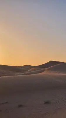 a sunset over the sand dunes of the desert at Sahara Authentic Berber Camp in Mhamid