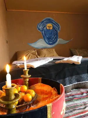 a room with a bed with a table with candles at Sahara Authentic Berber Camp in Mhamid