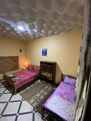 a room with two beds and a ceiling at Villa familys in Fès