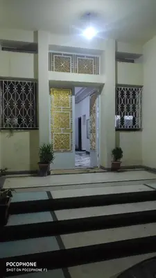 an empty room with a door and potted plants at Villa familys in Fès