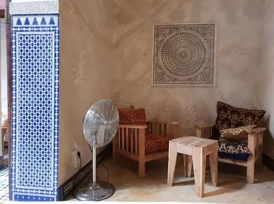 a living room with a fan and a chair at House in the old Medina of Fez in Fès al Bali