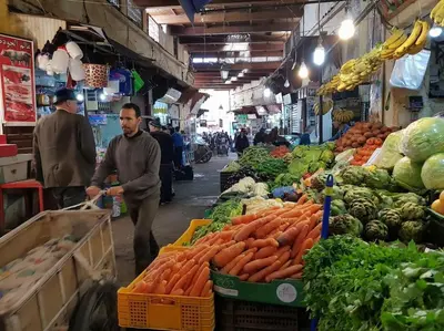 a man in a market with carrots and other vegetables at House in the old Medina of Fez in Fès al Bali