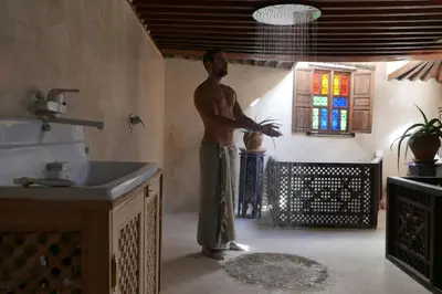 a man standing in a bathroom with a sink at House in the old Medina of Fez in Fès al Bali