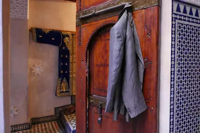 a wooden door with a coat hanging on it at House in the old Medina of Fez in Fès al Bali