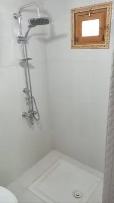 a bathroom with a shower with a toilet and a window at Chez L'habitant Brahim kanih in Anzel