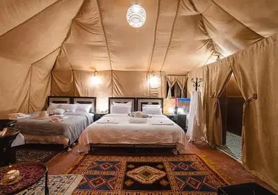 a bedroom with two beds in a tent at Amazing Desert Luxury Camp in Merzouga