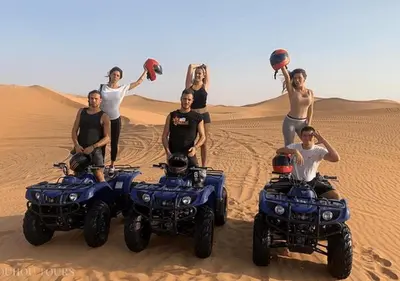 a group of people standing in the desert with atvs at Amazing Desert Luxury Camp in Merzouga