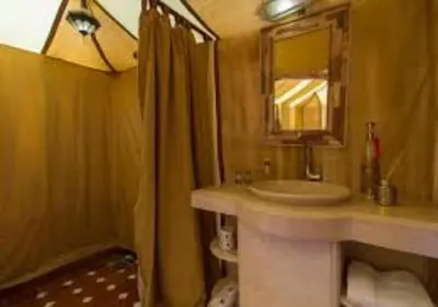 a bathroom with a sink and a mirror and a shower at Amazing Desert Luxury Camp in Merzouga