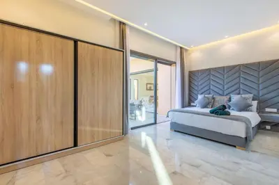 a bedroom with a bed and sliding glass doors at Villa Hawai, ss vis à vis avec espace de sport , piscine Chauffée in Marrakech