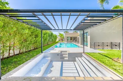 an outdoor pool with a pergola next to a house at Villa Hawai, ss vis à vis avec espace de sport , piscine Chauffée in Marrakech