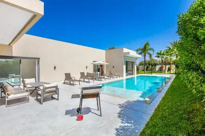 a villa with a swimming pool and a patio at Villa Hawai, ss vis à vis avec espace de sport , piscine Chauffée in Marrakech