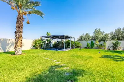 a palm tree in a yard with a gazebo at Villa Hawai, ss vis à vis avec espace de sport , piscine Chauffée in Marrakech