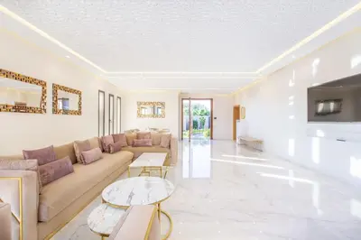 a living room with a couch and a table at Villa Hawai, ss vis à vis avec espace de sport , piscine Chauffée in Marrakech