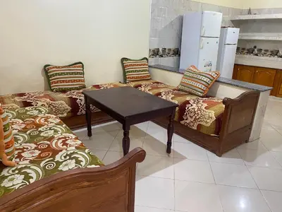 a room with two couches and a table and a kitchen at Appartement Ain Asserdoun in Beni Mellal