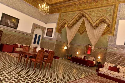 a dining room with a table and chairs in a building at Youssef in Fès