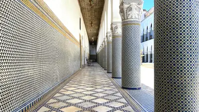a hallway of a building with columns and tiled floors at Youssef in Fès