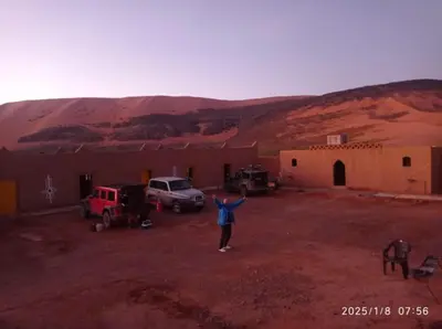 a person standing in front of a building in the desert at Auberge Hassi Fougani in Tafraoute Sidi Ali