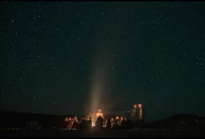 a group of people standing under a starry sky at Auberge Hassi Fougani in Tafraoute Sidi Ali