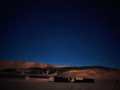 a building in the middle of a desert at night at Auberge Hassi Fougani in Tafraoute Sidi Ali