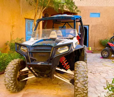 a blue atv parked in front of a building at Ryad lcaid in Tissint