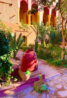 a large red vase sitting on the side of a sidewalk at Ryad lcaid in Tissint